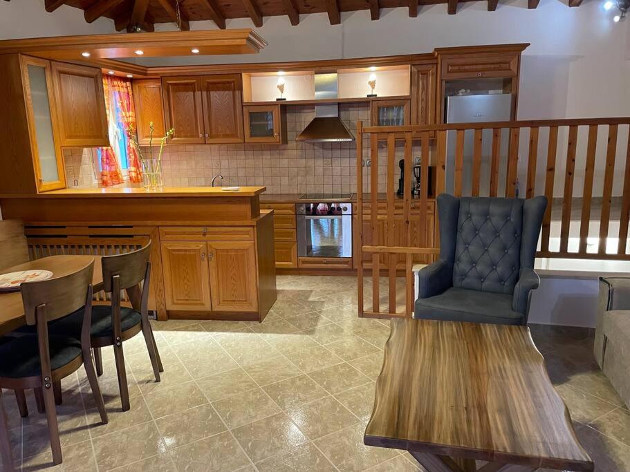斯基亚索斯镇Like my house的厨房配有木制橱柜、桌子和椅子