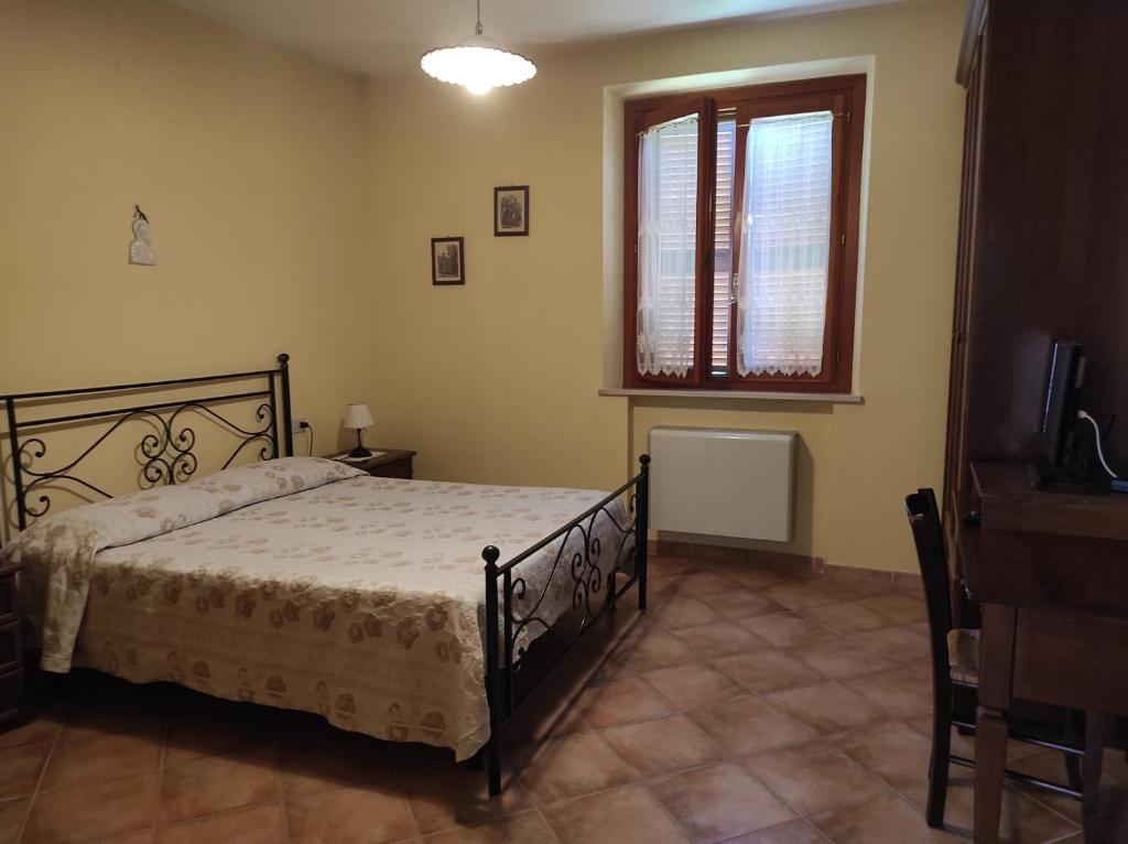 卡斯特姆苏Il Colombaiolo的一间卧室设有一张床、一个窗口和一台电视