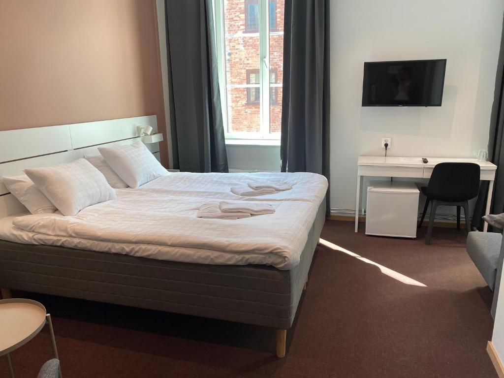 耶夫勒Ahlgrens Hotell Bed & Breakfast的一张床位,位于带书桌和床的西德西德西德(Sidx sidx)客房内