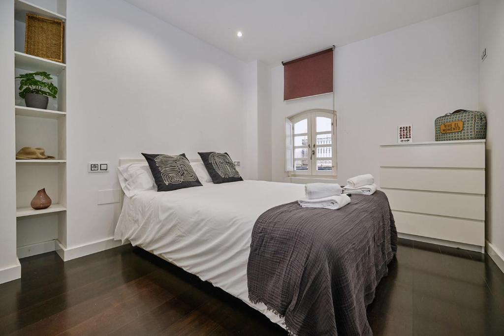 拉科鲁尼亚Galera51 by Serendipia Turismo的一间卧室配有带白色床单和枕头的床。