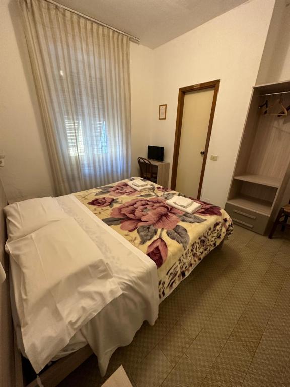 斯培西亚奥罗拉酒店的一间设有一张床铺的卧室,位于一个带镜子的房间