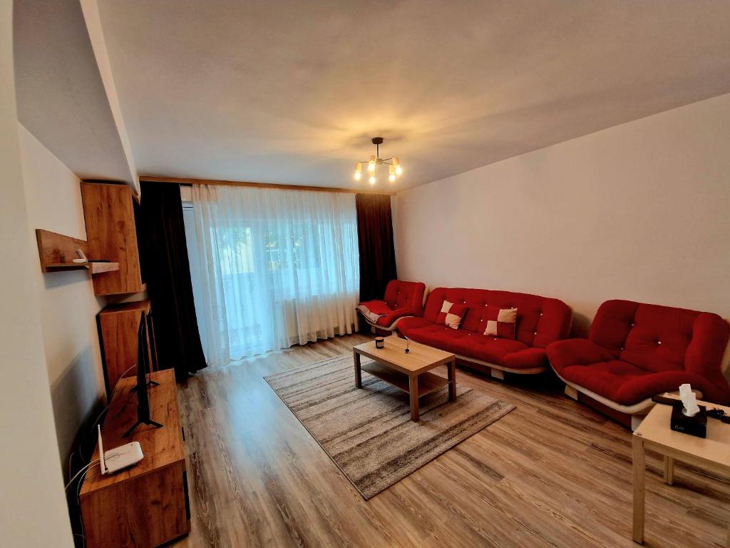 特尔戈维什泰Maribelle Appartments的客厅配有红色的沙发和桌子