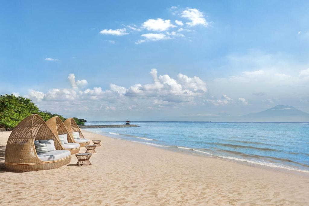 努沙杜瓦The Westin Resort Nusa Dua, Bali的海滩上一排椅子,与大海交汇