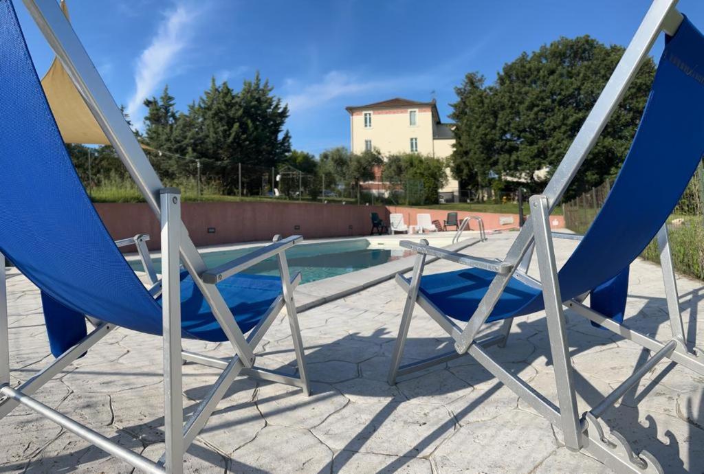 Montalto delle MarcheLa Dispensa的两把蓝色椅子坐在游泳池旁