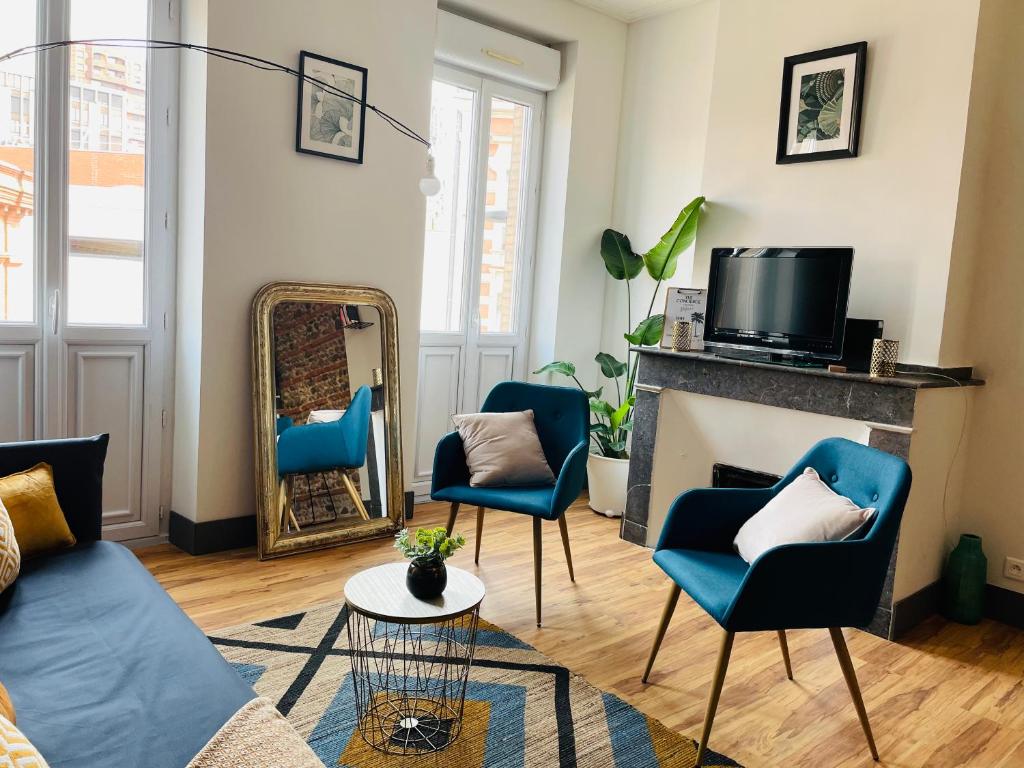 图卢兹Appartement climatisé avec balcon et parking privé的客厅配有蓝色椅子和壁炉