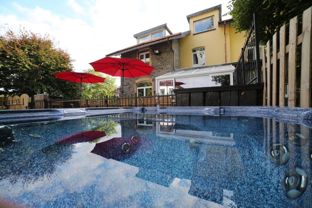 弗朗科尔尚Dolce Villa Pool and Wellness的一个带两把遮阳伞和房子的游泳池