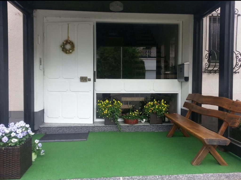 奥尔珀Ferienwohnung & Zimmer的门廊,带长凳,门上鲜花盛开