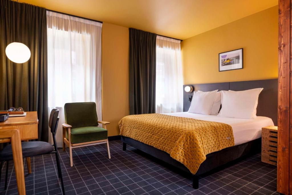敦刻尔克Best Western Plus Hotel Cargo的酒店客房配有一张床、一张桌子和一把椅子。