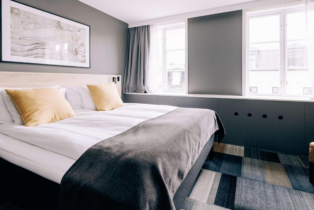 卡尔斯克鲁纳Best Western Plus JA Hotel Karlskrona的一间卧室设有一张大床和两个窗户。