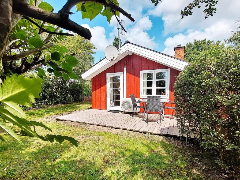 海默特4 person holiday home in Hemmet的木制甲板上的一个红色小房子