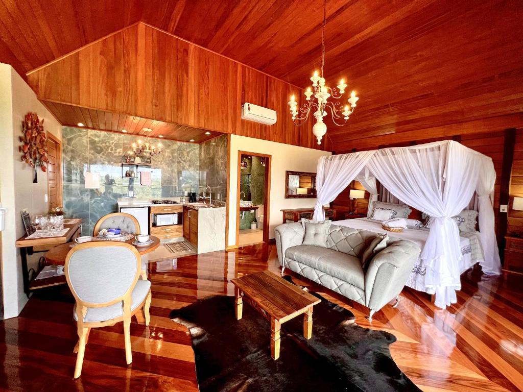 新文达移民镇Chalés Grecco的客厅配有沙发和桌子