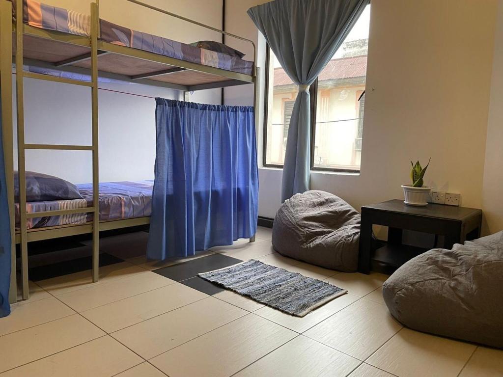 怡保Marina Hostel的一间卧室设有两张双层床和一张桌子