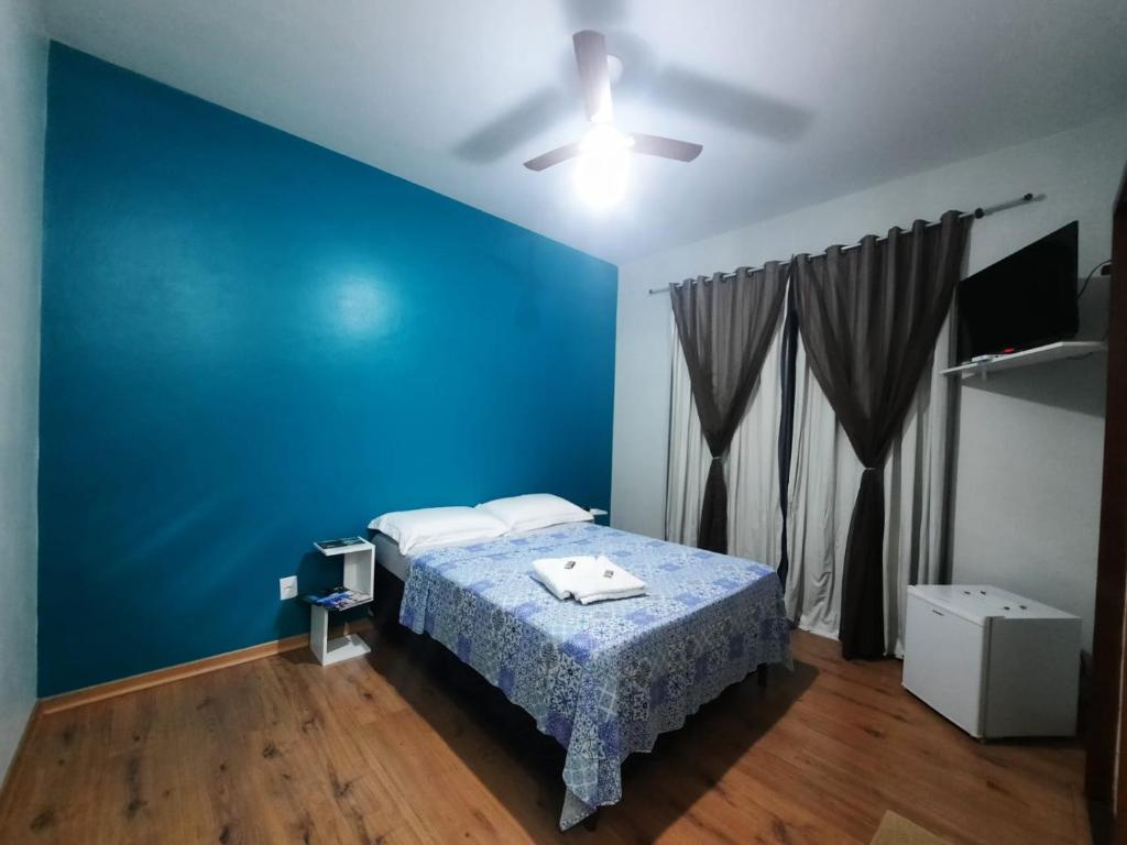 卡尚布Alvorada Guest House的蓝色的卧室,配有床和蓝色的墙壁