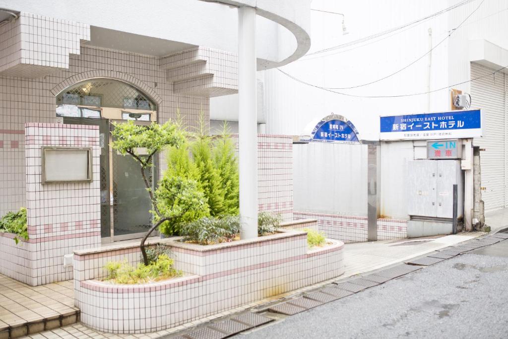 东京东新宿酒店的街道边有植物的建筑