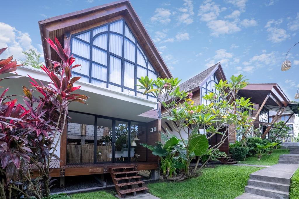 克罗柏坎Villa Atra Bambulogy by Nagisa Bali的一座拥有许多窗户和植物的房子