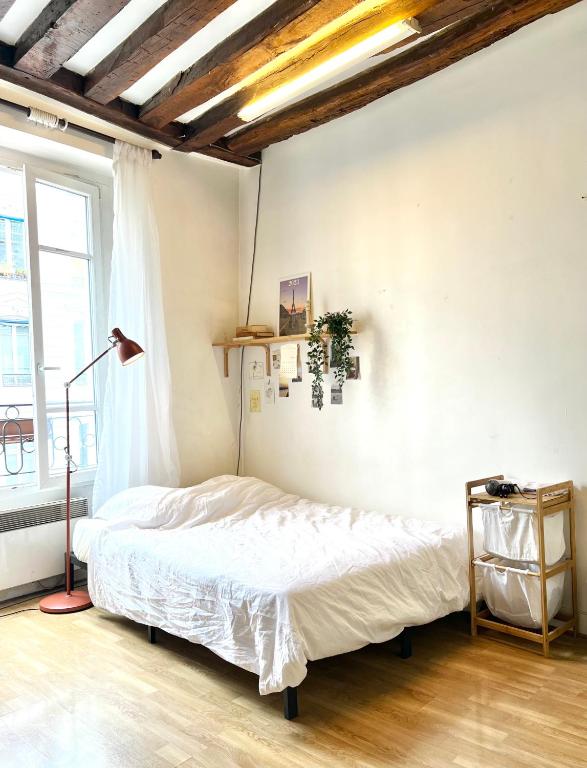 巴黎[New] Cozy studio Center of PARIS / Bourse的一间卧室配有床、灯和窗户