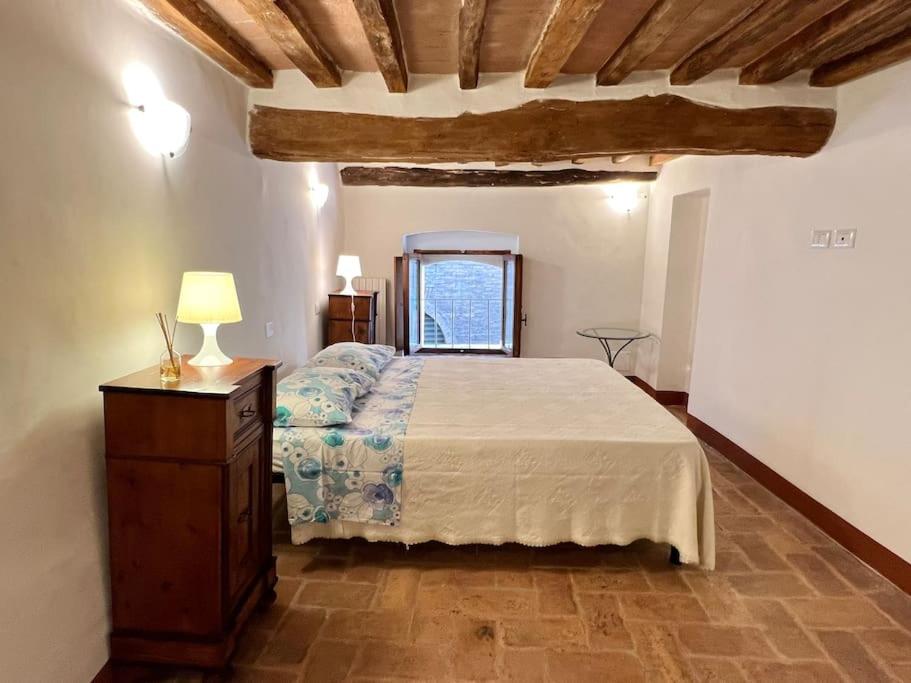锡耶纳Franciosa Lodge - Cattedrale的一间卧室配有一张床和一张带台灯的桌子