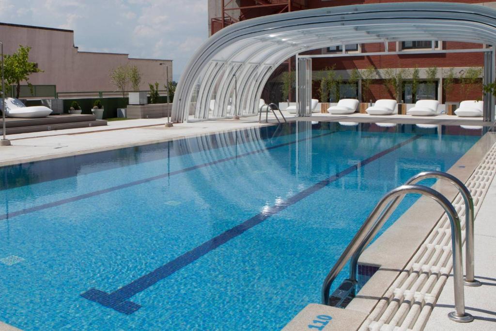 马德里马德里礼堂万豪会议中心酒店 的大楼内一个蓝色的大型游泳池