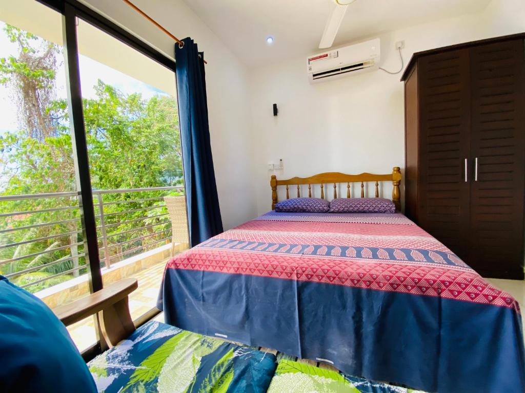 贝尔欧布莱Oceanic View Lodges的一间卧室设有一张床和一个大窗户