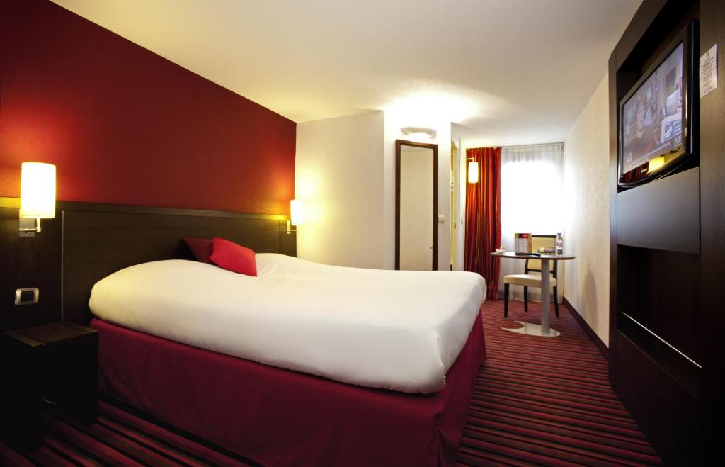 贝尔福宜必思式贝尔福中心酒店的酒店客房设有一张大床和一台电视。