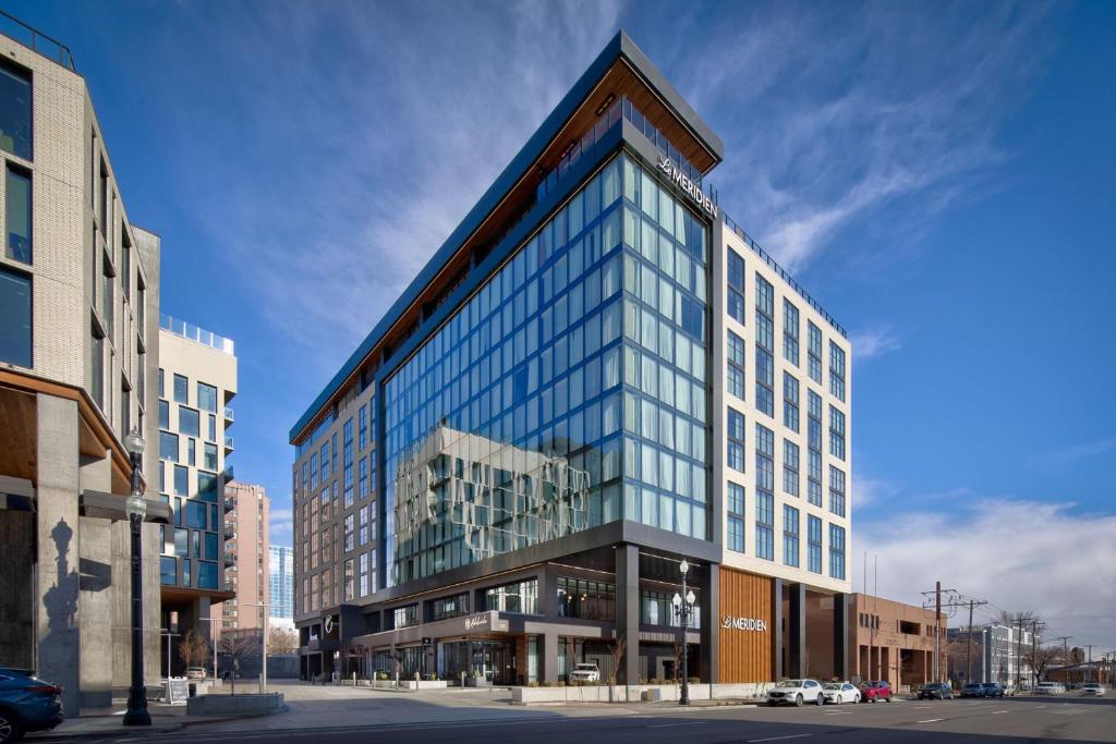 盐湖城Le Méridien Salt Lake City Downtown的城市街道上一座高大的建筑,设有玻璃窗