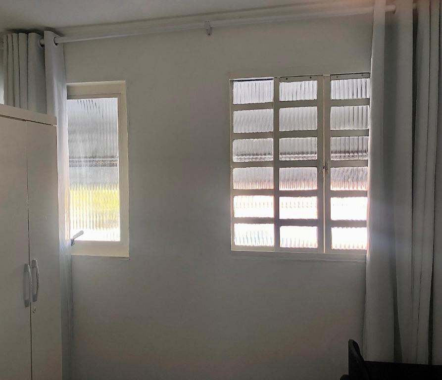 巴西利亚Pousada 714的白色的客房设有2扇窗户和1扇门