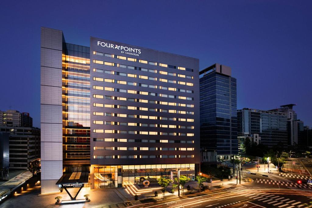 首尔Four Points by Sheraton Seoul, Guro的一座高大的建筑,上面有城市的标志