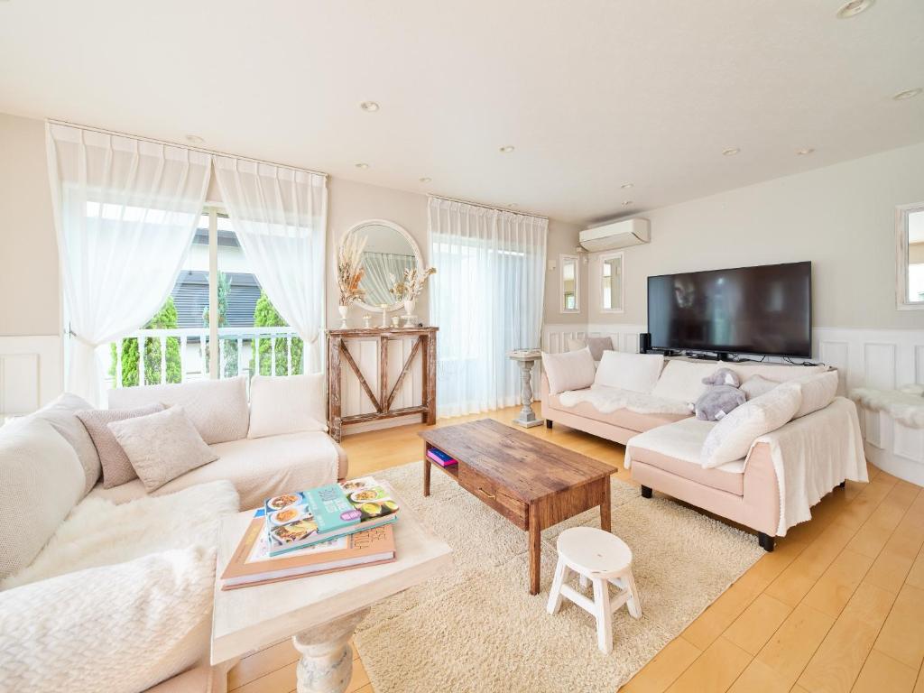 横须贺市Villa OLIVE Sajima -佐島の丘- ペット可的客厅配有白色家具和电视