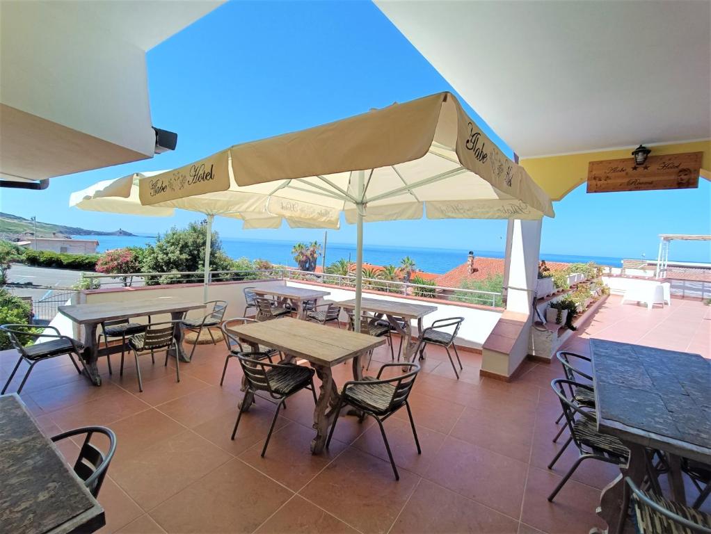 特雷斯努拉吉斯Alabe Hotel的一个带桌椅的海景庭院