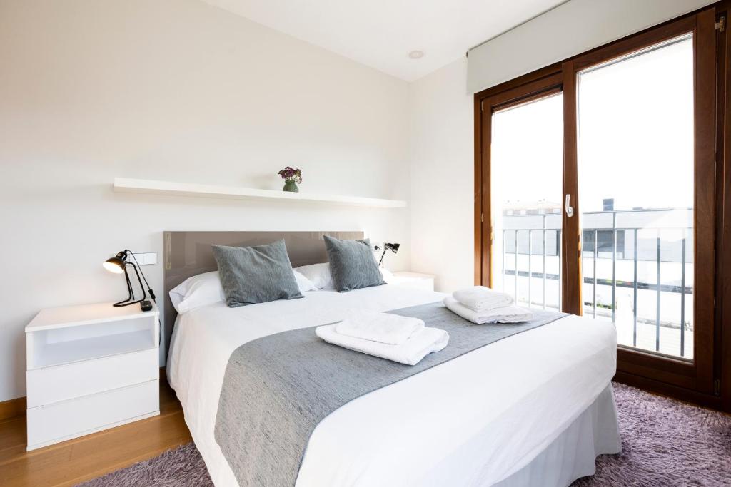 宏达瑞比亚Jaizkibel by Basquelidays的白色的卧室设有一张大床和一个窗户