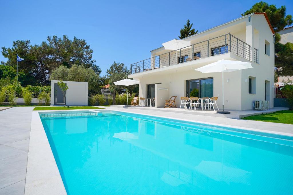 波托什Filoxenia Luxury Apartments的一座带游泳池和房子的别墅