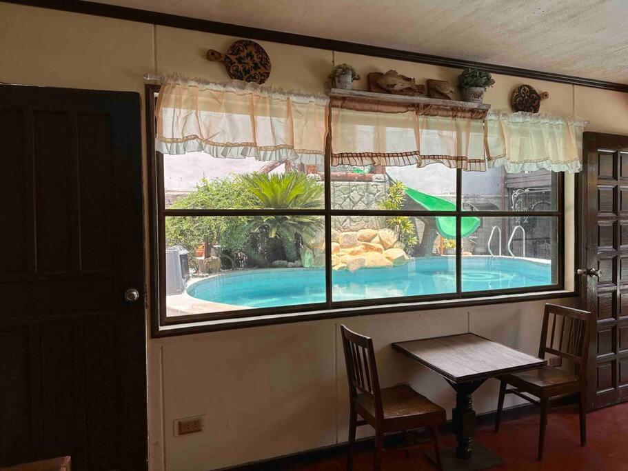 卡兰巴Hotspring Resort with Videoke的透过窗户可欣赏到游泳池的景色