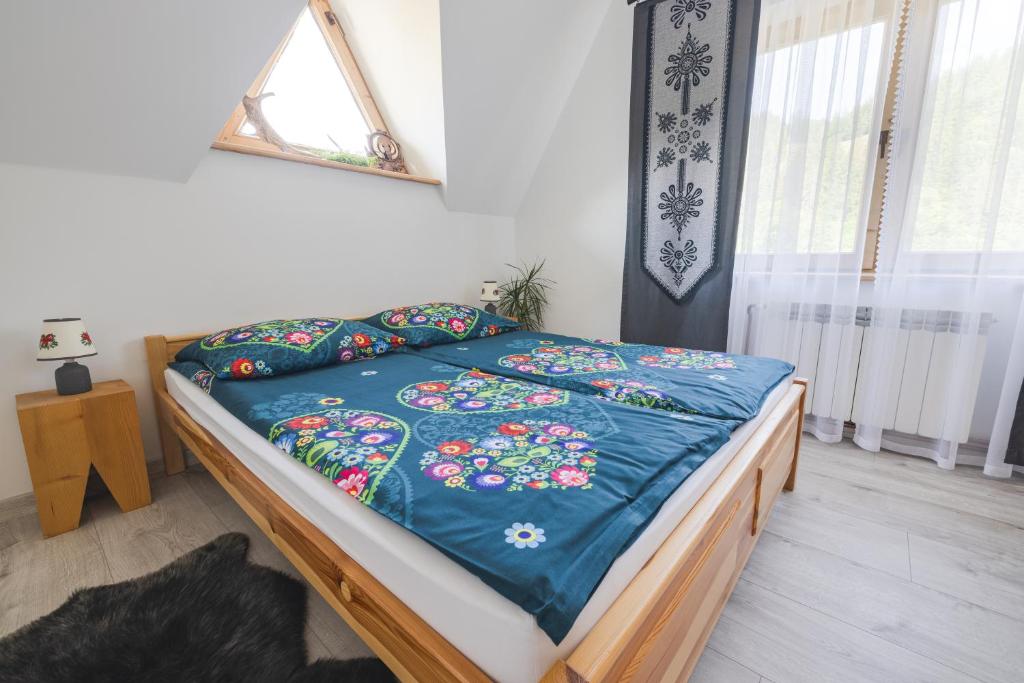扎科帕内Pokoje na Równi Zakopane的一间卧室配有一张带蓝色棉被的床