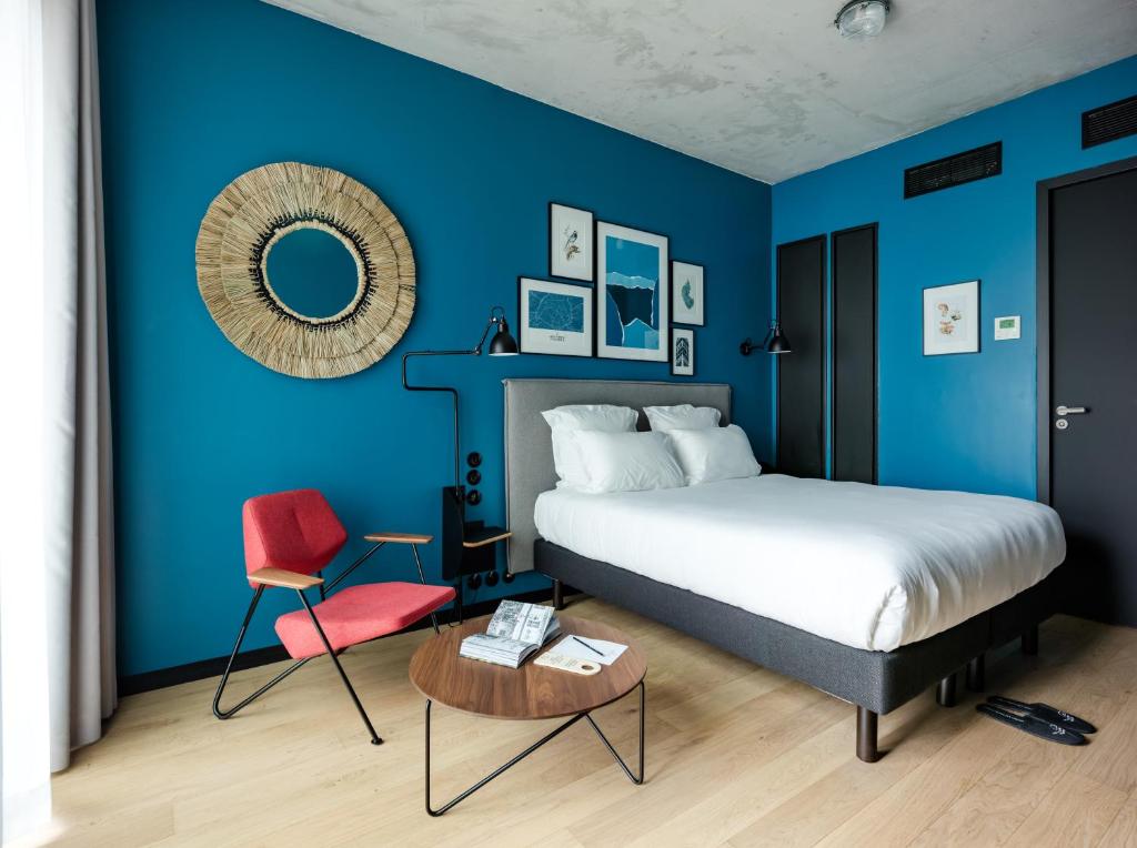 巴黎Deskopolitan House的蓝色卧室,配有床和红色椅子