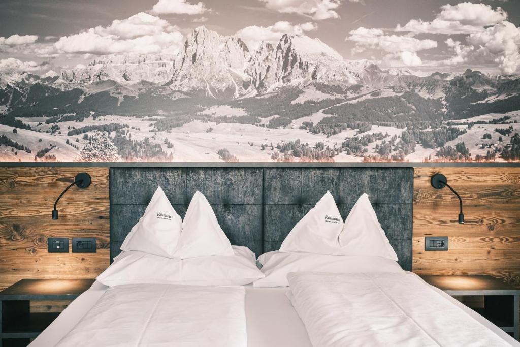 塞尔瓦迪加尔代纳山谷Kristiania Small Dolomites Hotel的一间带两张床和山壁画的卧室
