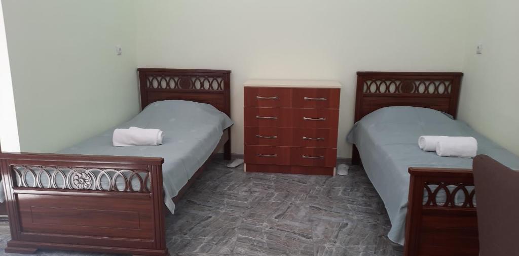 Garninew garni 1的一间带两张床和木制梳妆台的卧室