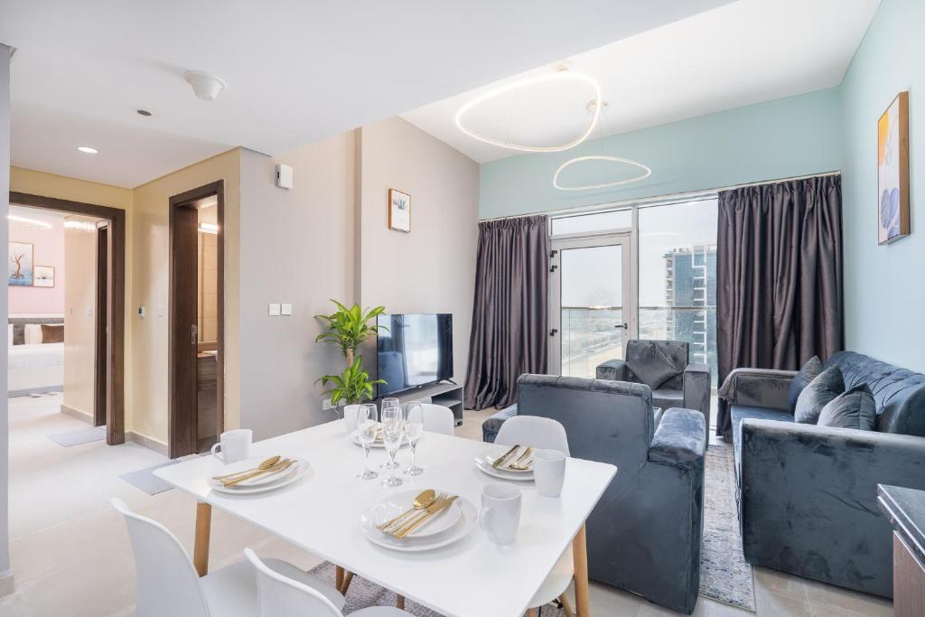 迪拜Trinity Holiday Homes - Spacious Modern Living 2BR Unique Apartment的客厅配有白色的桌子和椅子