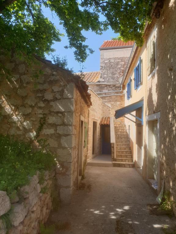 马里伊兹Beautiful rustikal Stone House的一条有树木的老石头建筑的小巷