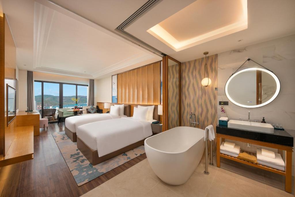 归仁Grand Hyams Hotel - Quy Nhon Beach的酒店客房设有床、浴缸和水槽