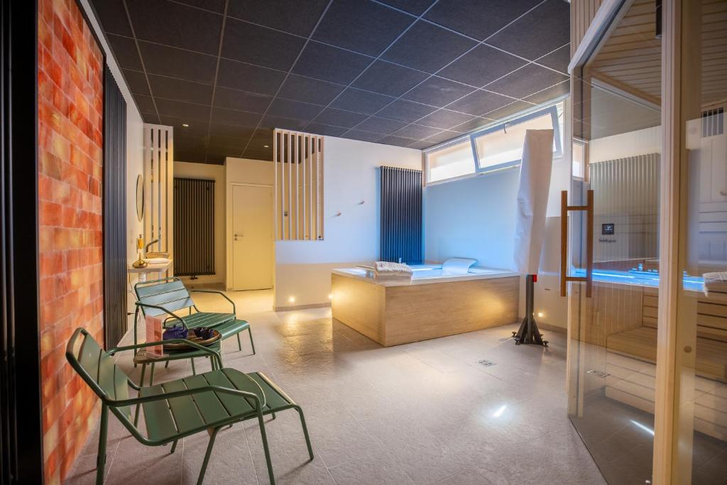 弗农诺曼底酒店的一间设有两张绿色椅子的房间和一间卧室