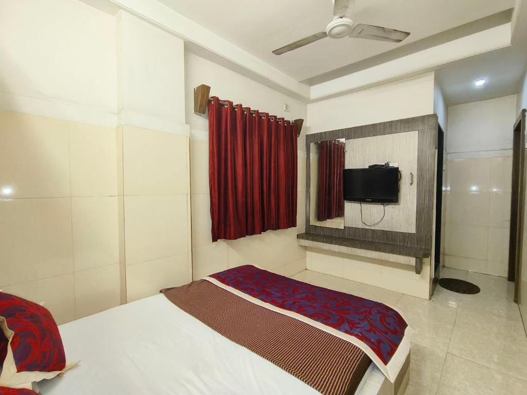舍地HOTEL SAI PRABHU INN的一间卧室配有一张床和一台电视。