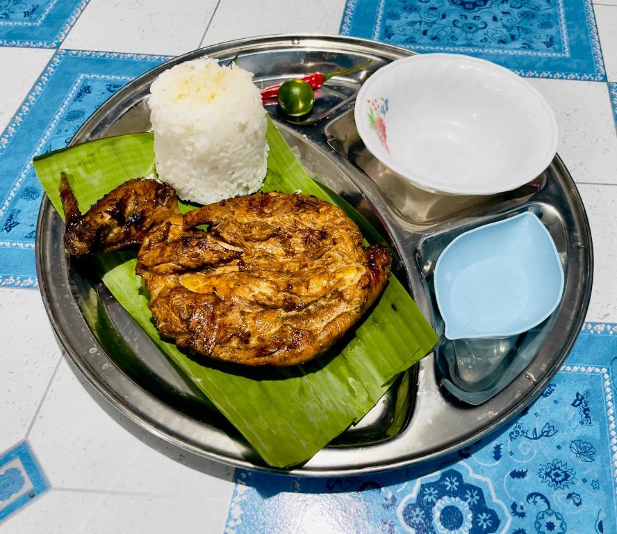 TubigonBossing Inasal的餐桌上一盘带肉和米饭的食物
