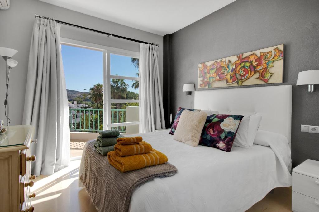 福恩吉罗拉Apartamento en complejo con piscina, pádel y restaurante con vistas al golf en Mijas - Matchroom 83的卧室设有白色的床和大窗户