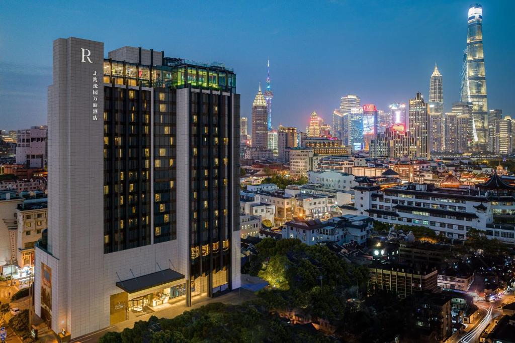 上海上海豫园万丽酒店的一座高大的建筑,在晚上有城市天际线