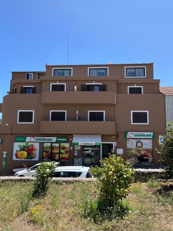 蒙希克Miradouro da Serra的前面有停车位的建筑