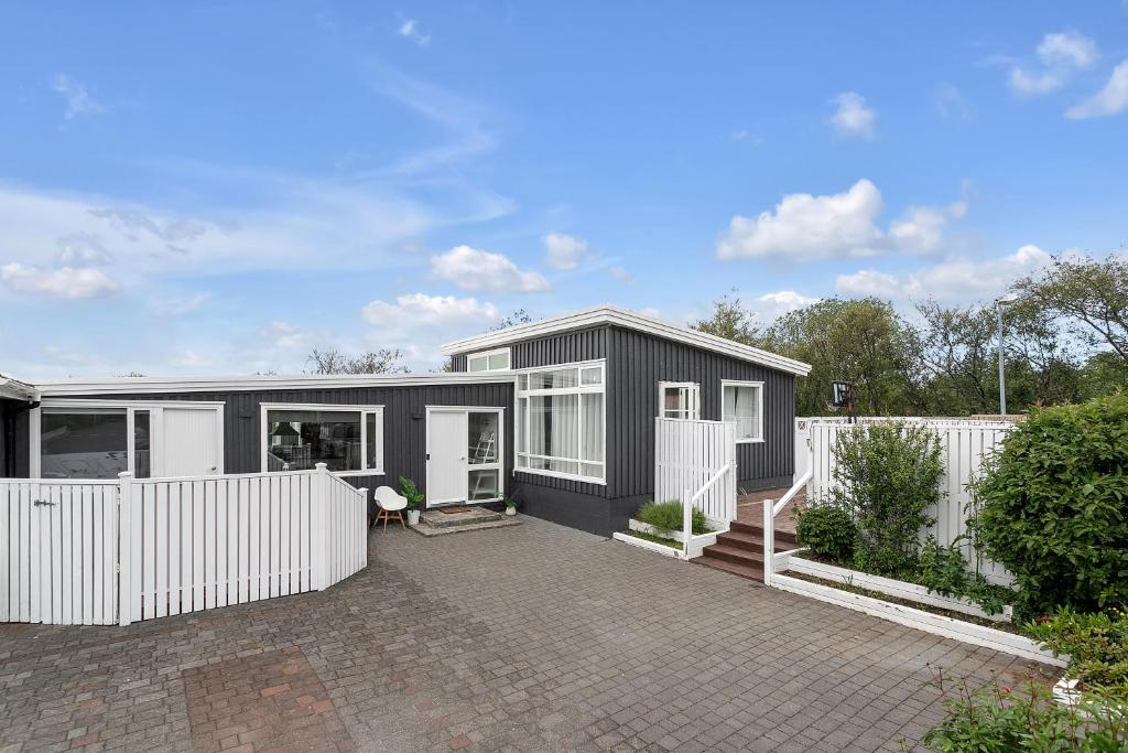 GarðabærFamily house with garden, Hot Tub Near Reykjavík的白色的黑色房子,有白色的围栏