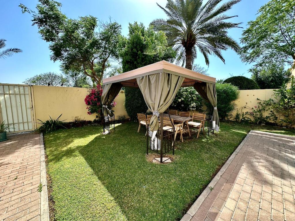 迪拜Lux BnB Springs Villa Private Garden的庭院内带桌椅的凉亭
