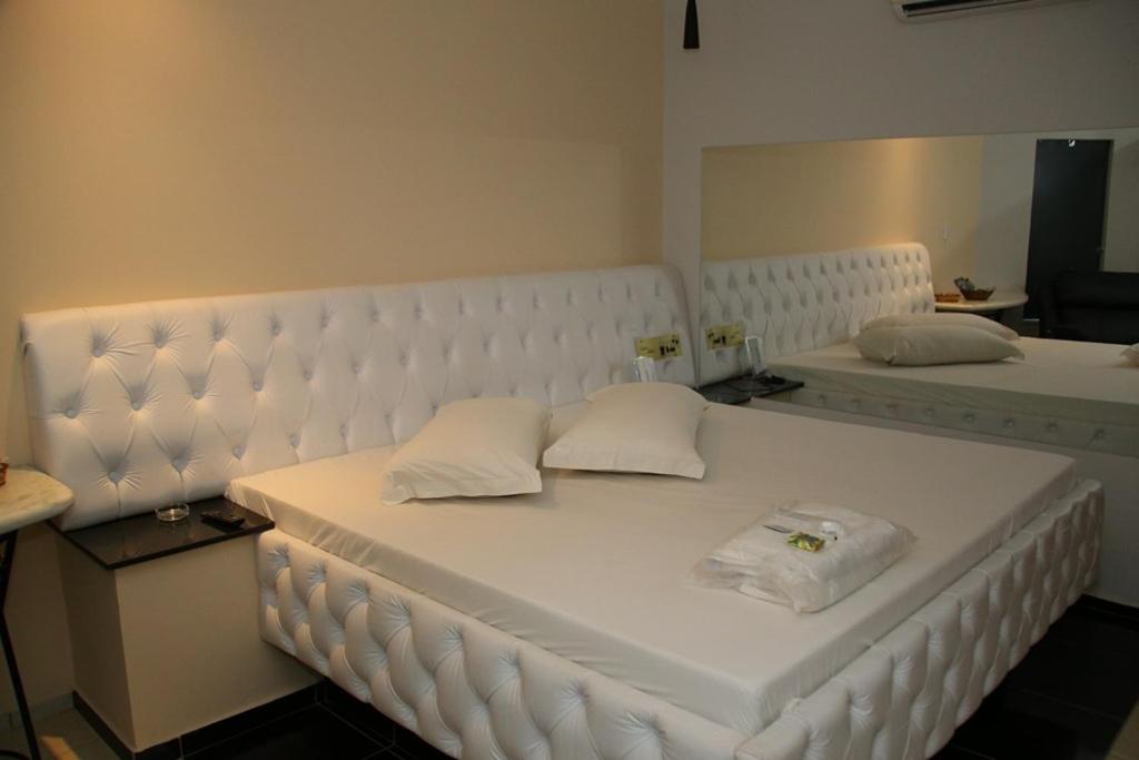 费尔南多波利斯SAFIRA MOTEL II的一张白色的床,上面有两个枕头