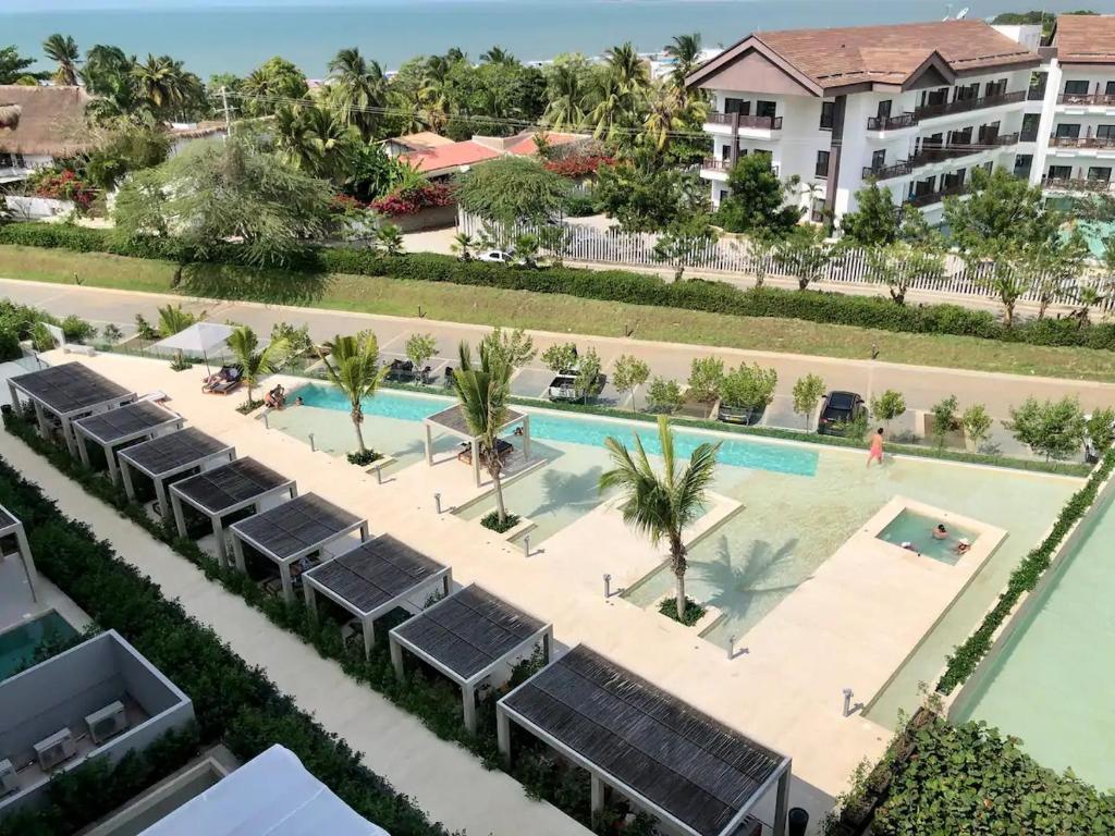 La SiriacaApartamento con vista al mar en condominio de lujo的享有度假村游泳池的空中景致