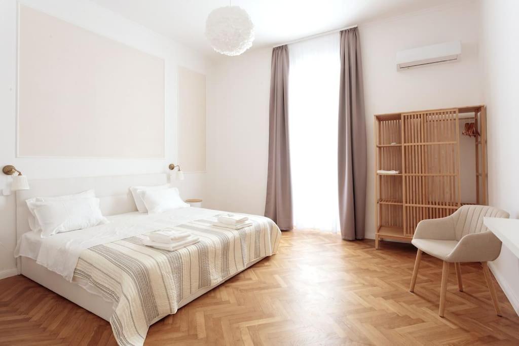 普拉Central Pula - Charming Historic Gem - Modern Comforts的白色卧室配有一张大床和椅子